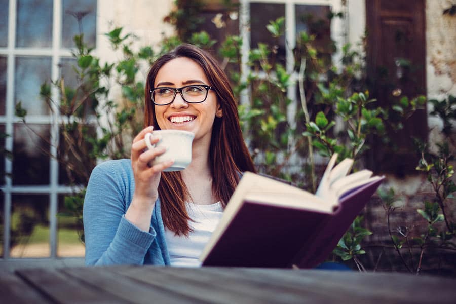 Woman reading a book and drinking coffee