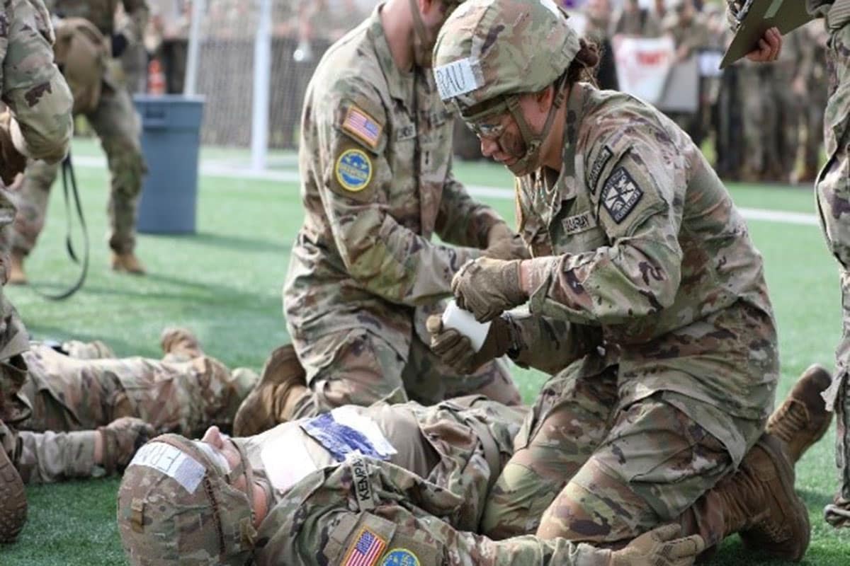 Laina Tallman-Bogusta completes tactical combat casualty care on fellow cadet Michael Kempany
