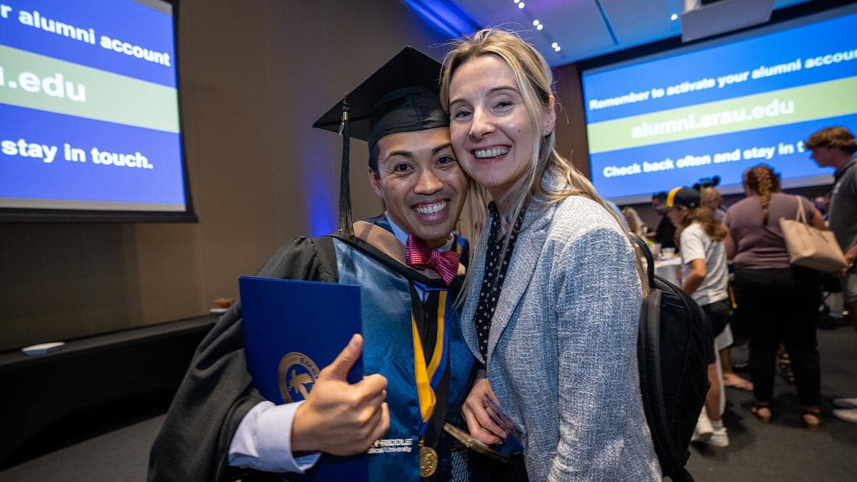 Women embrace at graduation.