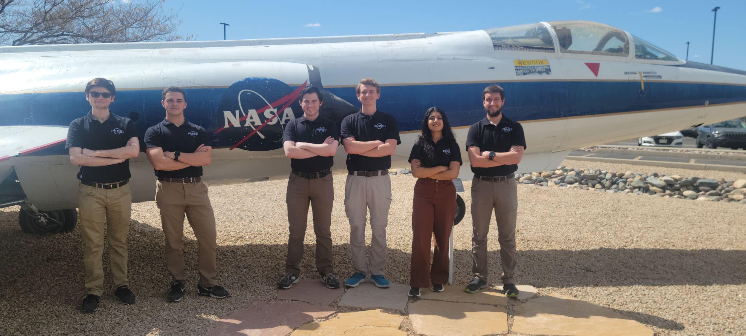 Students stand by a plane.