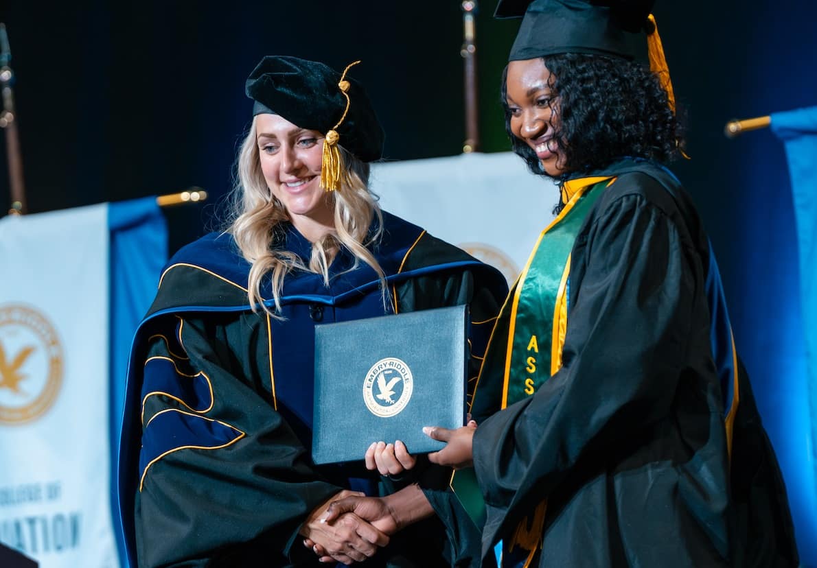 Woman accepts her diploma at graduation