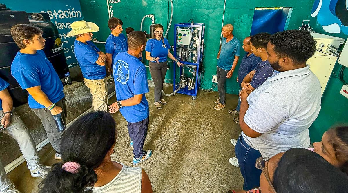 Young woman next to water purifier machine in the Dominican Republic