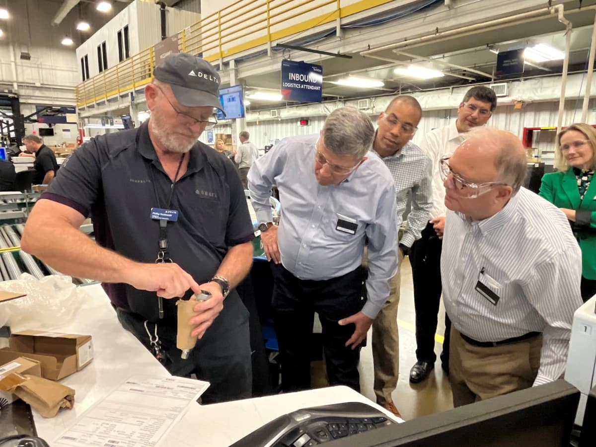 Men look at Delta plane parts.