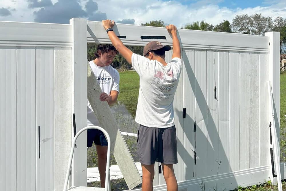 Pi Kappa Alpha Fraternity brothers Brady Andrews and Marcus Lopez rebuild a storm-damaged fence at the Domestic Abuse Council’s emergency shelter in Volusia County