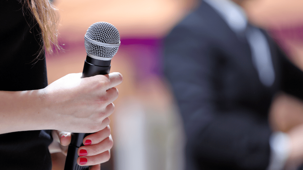 woman holds a microphone