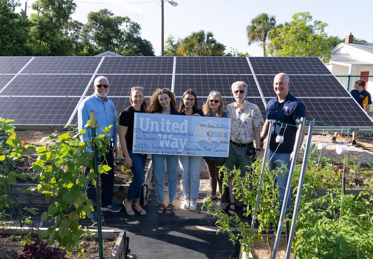 Students with garden and solar panel project