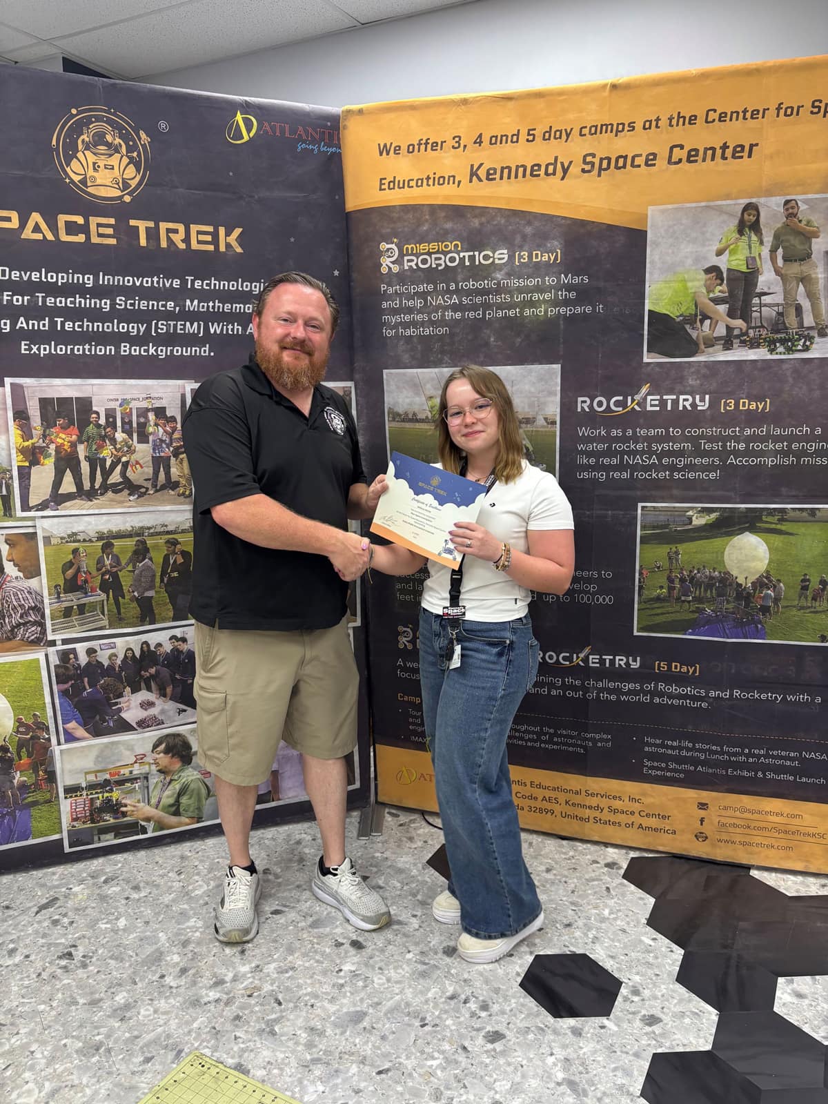 Melick receives a congratulations from Andrew Gafford, who is a research and development engineer at the Space Trek Academy.