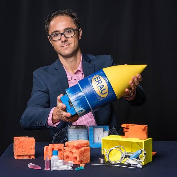 Pedro Llanos displays the CRExIM payload that was designed by Embry-Riddle students to study the effects of microgravity on T-cells.