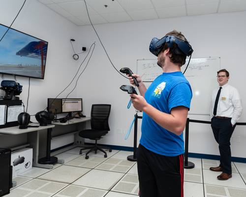 Trevor Goodwin, Embry-Riddle’s new Virtual Reality Lab manager, watches as student Alec Bischoff goes through a step-by-step pre-flight inspection of a simulated Cessna 172 aircraft.