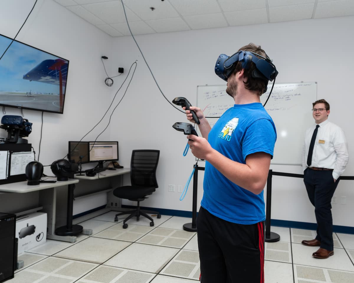 Trevor Goodwin, Embry-Riddle’s new Virtual Reality Lab manager, watches as student Alec Bischoff goes through a step-by-step pre-flight inspection of a simulated Cessna 172 aircraft.