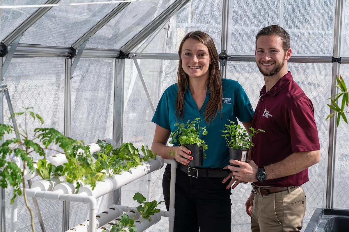 Recent graduate Deanna DeMattio, a flight instructor, and current student Nicholas McGuire use a greenhouse and hydroponics to grow “superfoods” that could be used to feed astronauts on Mars. 