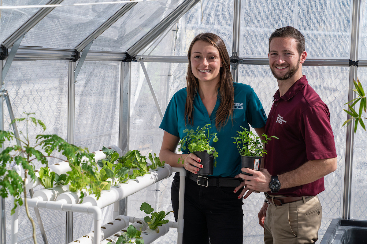 Recent graduate Deanna DeMattio, a flight instructor, and current student Nicholas McGuire use a greenhouse and hydroponics to grow “superfoods” that could be used to feed astronauts on Mars.
