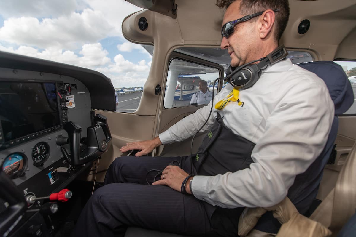 Dr. Braden McGrath, center, Research Professor for Validated Mathematical Model of Spatial Disorientation, holds his hand over a sensor that will monitor him, along with the torso vibration  band while testing haptics during a flight at Embry-Riddle Aeronautical University's Daytona Beach Campus.  