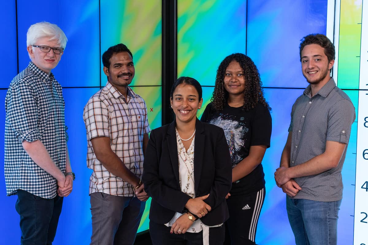 Dr. Kshitija Deshpande (center) joins her students (L-R) Chintan A. Thakrar, Pralay R. Vaggu, Danayit T. Mekonnen and Lucas Eduardo E. Tijerina Poinsot in front of a projection of ionospheric structures on the ground. 