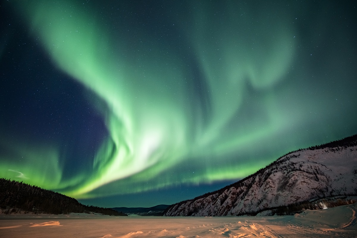 The aurora borealis, or northern lights, forms a green band, here over the Yukon Territory, in Canada.