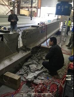 Assistant Professor Dan Su inspects a pre-stressed concrete beam connected to distributed optical fiber sensors at a FDOT facility.