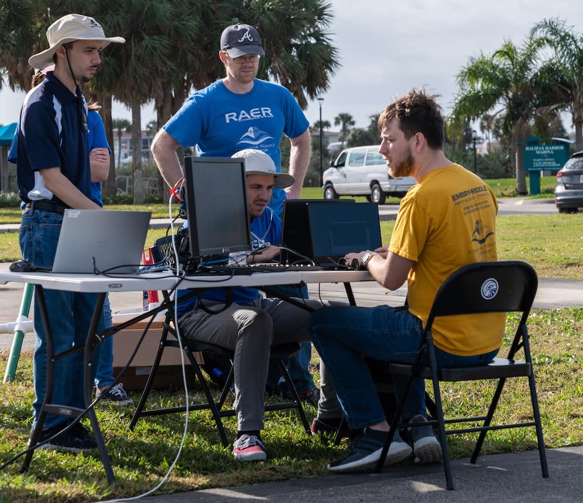 James Hendrickson, Matthew Helms, Eric Coyle and David Thompson work on ground station computers at the RobotX challenge, in 2019.