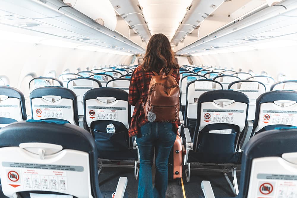 a woman boarding an empty airplane