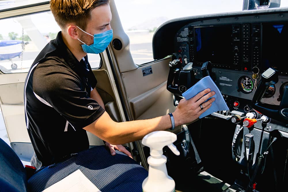 a student wiping down an aircraft