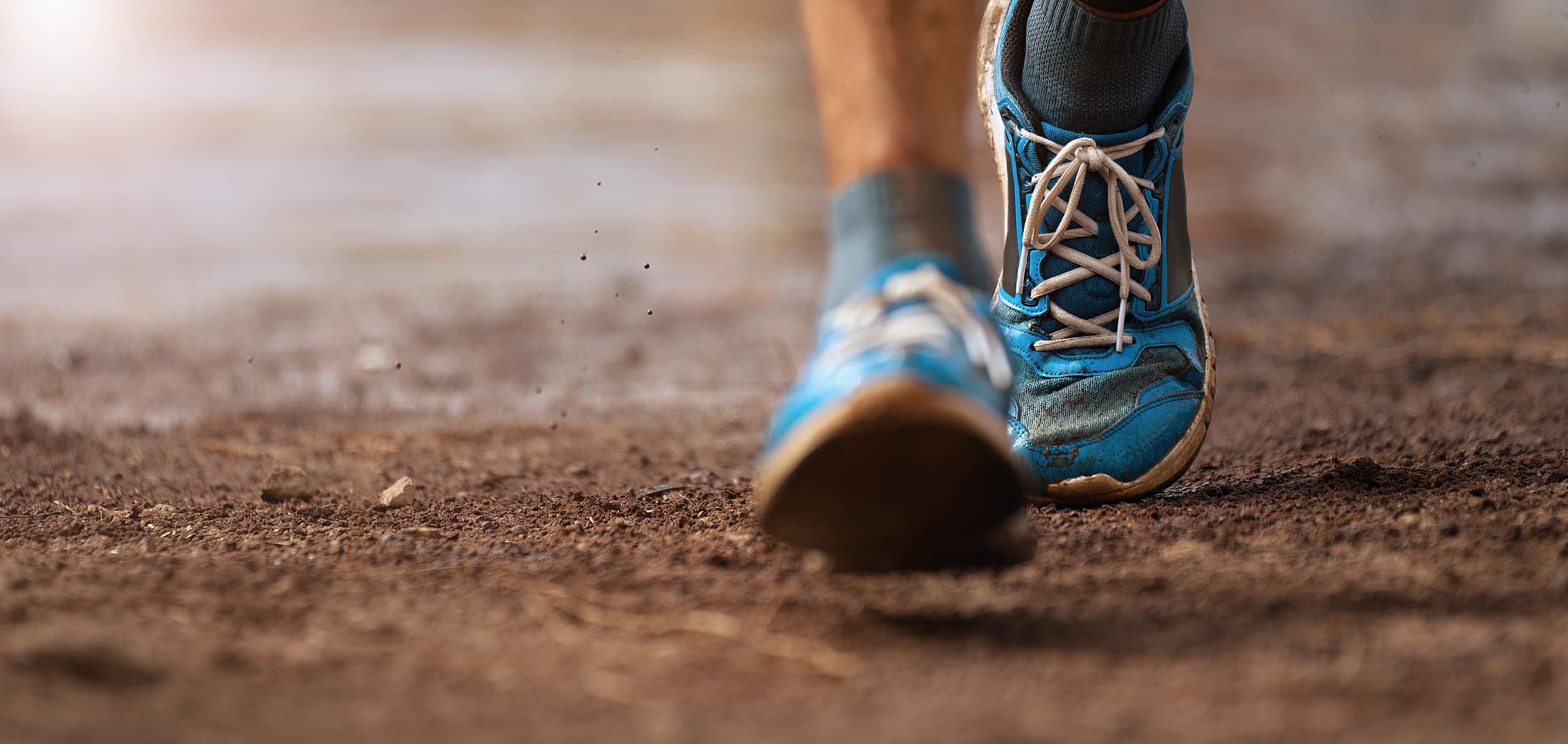 athletic shoes walking on a dirt track