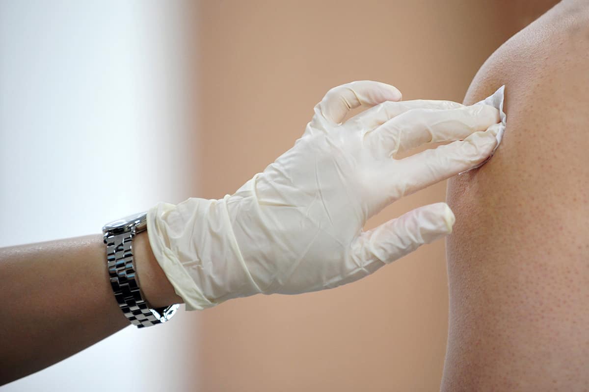  gloved hand helping with a flu shot