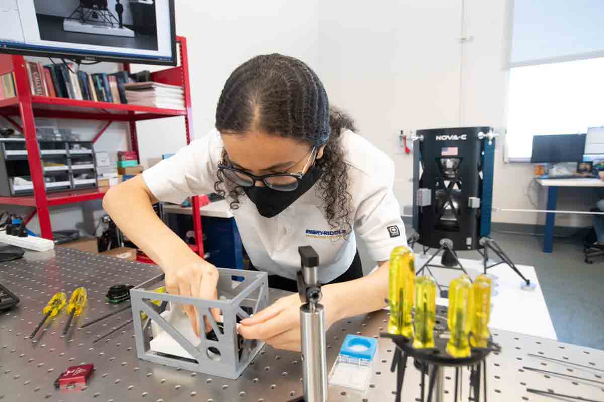 Jana Alaslani works at the optical table to assemble test components into a 3D-printed prototype of the EagleCam CubeSat camera system.