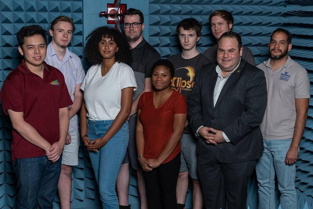 NSF Early Career Award Winner Dr. Eduardo Rojas (second from right) and his students are shown in the anechoic testing chamber in Embry-Riddle’s Wireless Devices and Electromagnetics (WiDE) Laboratory, which is part of the MicaPlex research facility. (Photo: Embry-Riddle/Daryl LaBello.)