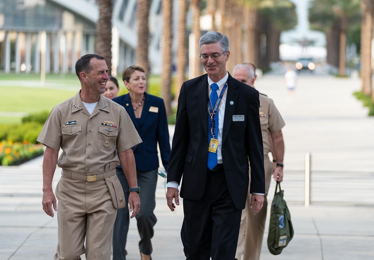 Dr. Butler walks with military personnel. 