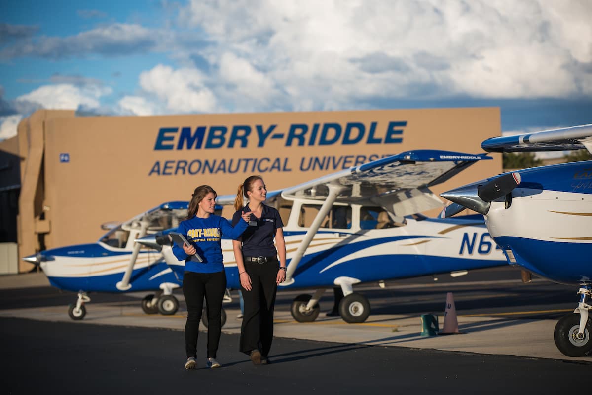 A student and flight instructor walk, mask-free, past the Prescott Campus fleet, before the Covid-19 pandemic necessitated the use of face coverings.