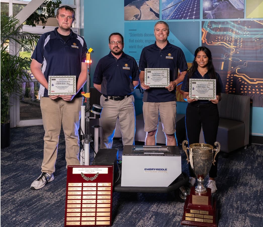 The Embry-Riddle Intelligent Ground Vehicle Competition Team, represented here by Andrew Strazds, faculty advisor Dr. Patrick Currier, Claude Watson III and Ana Alvarez, took first place overall in the 2021 Intelligent Ground Vehicle Competition, in Auburn Hills, Michigan. (Photo: Embry-Riddle/Daryl Labello)