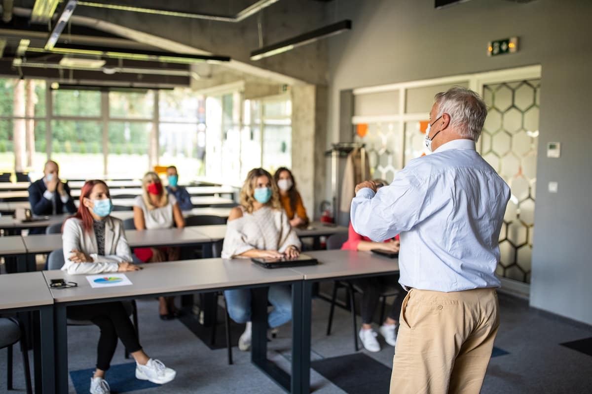 students and a professor wearing masks in a classroom