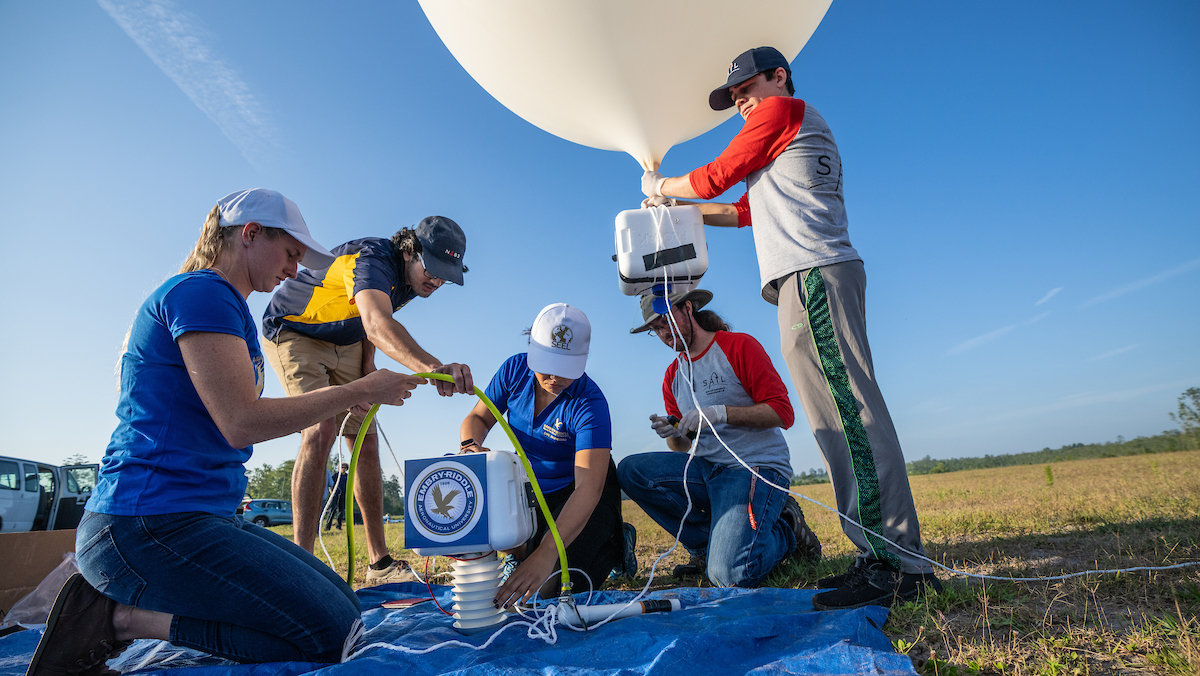 From left: Embry-Riddle students Devonne Friday and Avinash Muthu Krishnan; Dr. Marwa El-Sayed, assistant professor of Civil Engineering and director of the Sustainability and Environmental Engineering Lab (SEEL); Dr. Rob Clayton, research associate in the Space Atmospheric Instrumentation Lab (SAIL); and student Anthony Oreo prepare a weather balloon during a recent multidisciplinary test at Coe Field. (Photos: Embry-Riddle/David Massey)