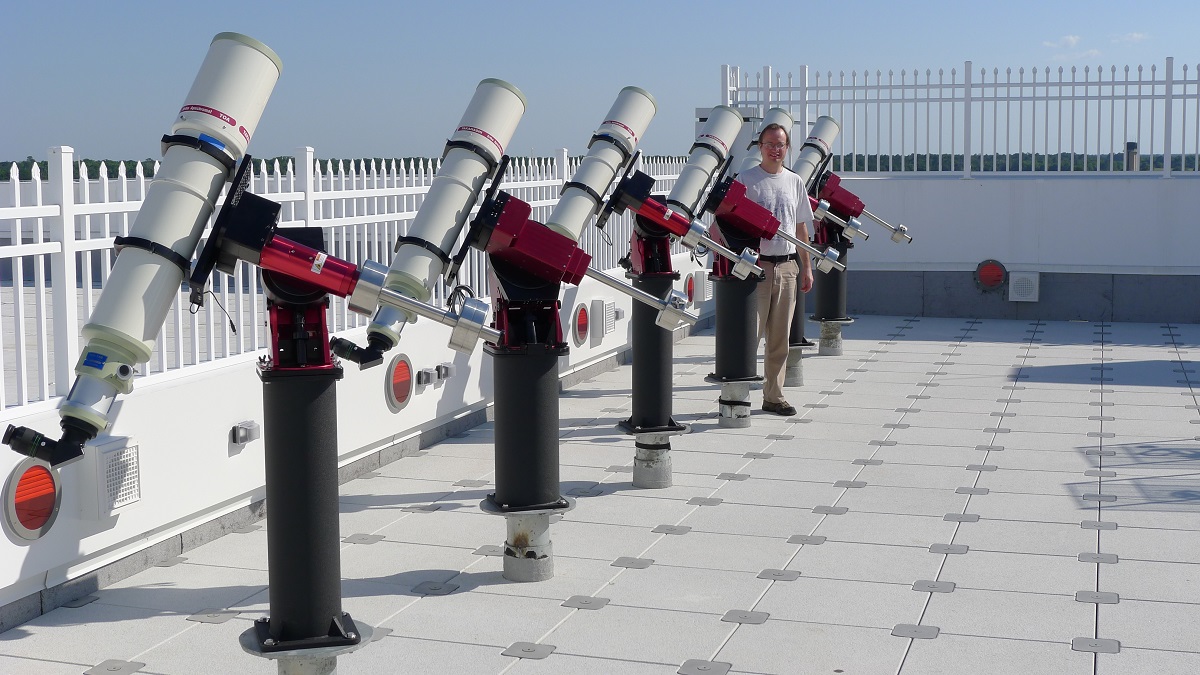 Associate professor of Physics and Astronomy Dr. Jason Aufdenberg stands with a line of telescopes on the observation deck of the College of Arts and Sciences’ roof. Six new telescopes will be added soon, for use in the upcoming fall semester. 