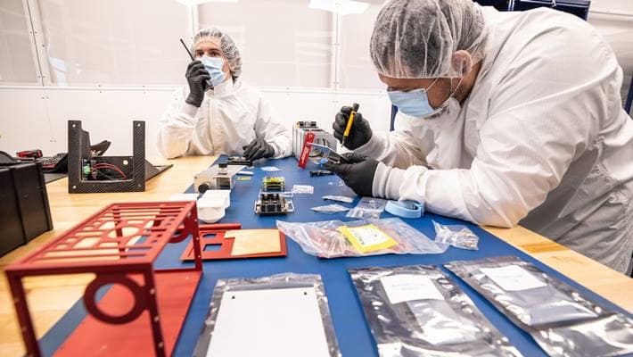 Lead engineers and doctoral students Daniel Posada and Chris Hays assemble the EagleCam cubesat in Embry-Riddle’s Space Technologies Lab.