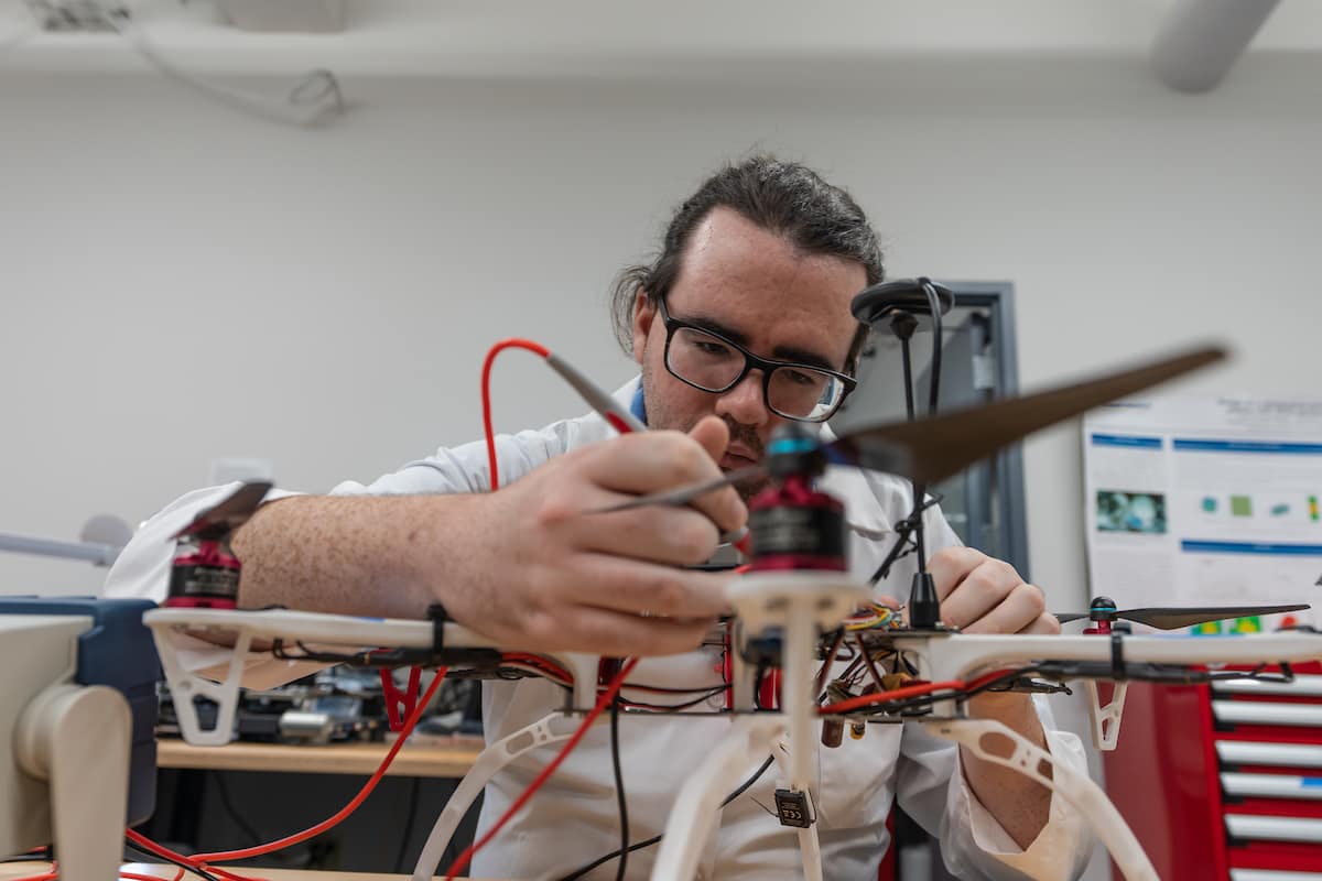 Electrical and Computer Engineering master’s student Justin Parkhurst tests connections in an unmanned system, or drone, using a multimeter, as well as uses a microscope and testing equipment to review circuitry, in Embry-Riddle’s Wireless Devices and Electromagnetics (WiDE) Laboratory, located in the Research Park. (Photos: Embry-Riddle/Daryl LaBello)