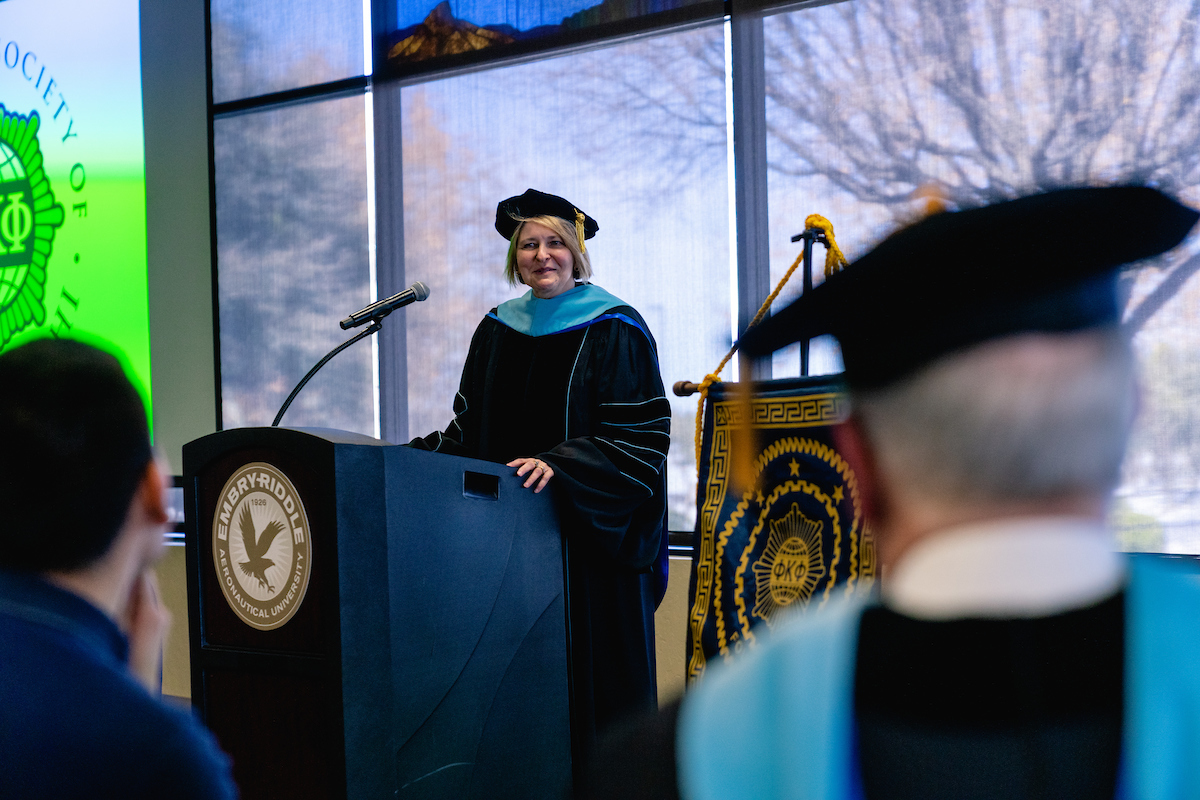 A new staff initiate into the Honor Society Phi Kappa Phi for Prescott Campus Chapter 337 addresses the assembly on the Society's motto Let the Love of Learning Rule Humanity