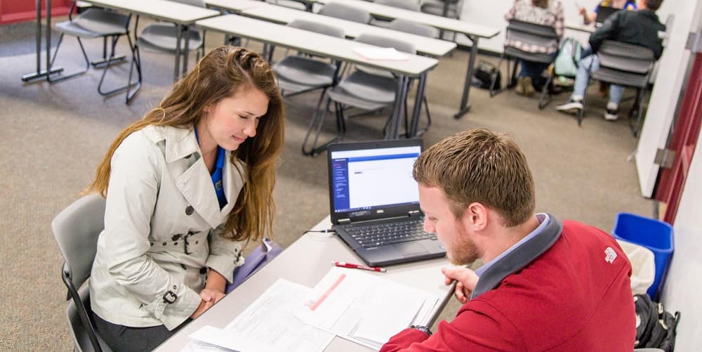 A business student helps prepare a tax return for a member of the Prescott community free of charge