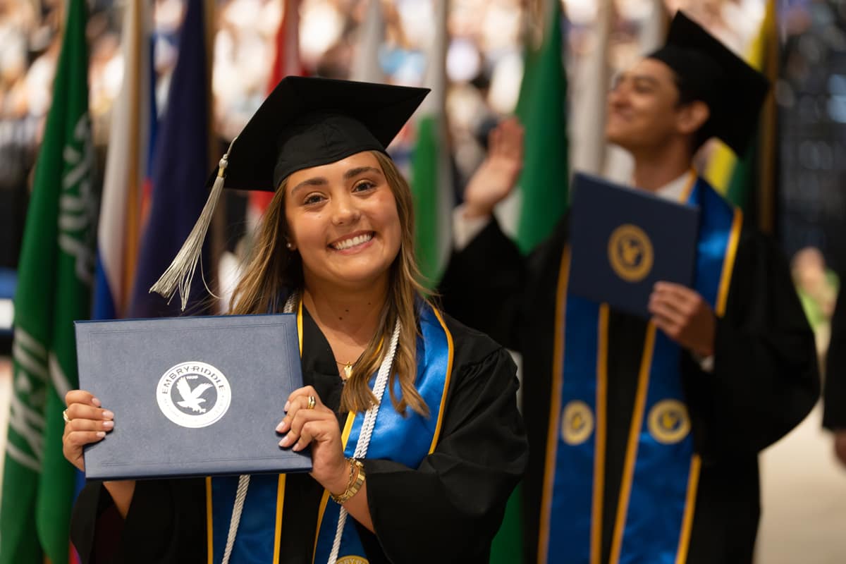 Student displays diploma walking off stage