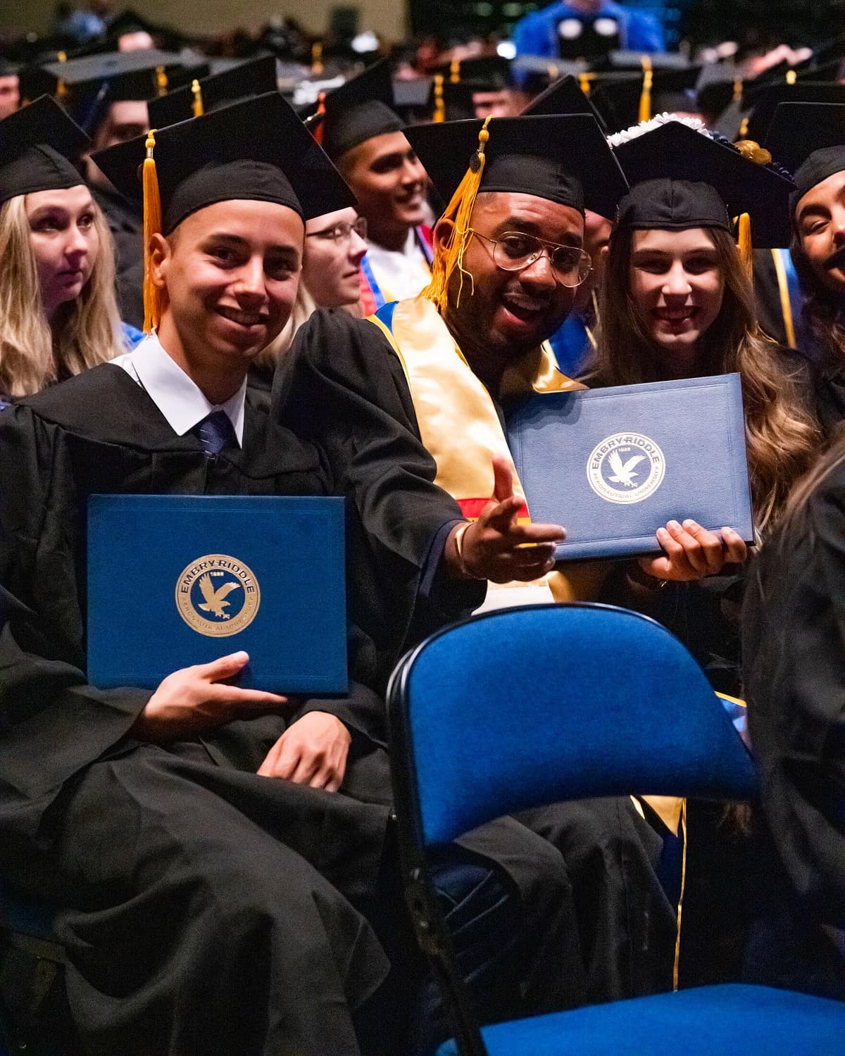 Students hold up degrees